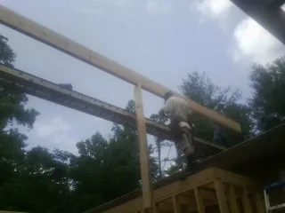 Carpenter setting a ridge beam over a new addition frame — Ice Dam Removal by Roofing Brothers in Mogadore