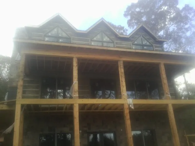 Dormers and porch framing on a large log home under construction — Roof Coating work by our crew in Mogadore
