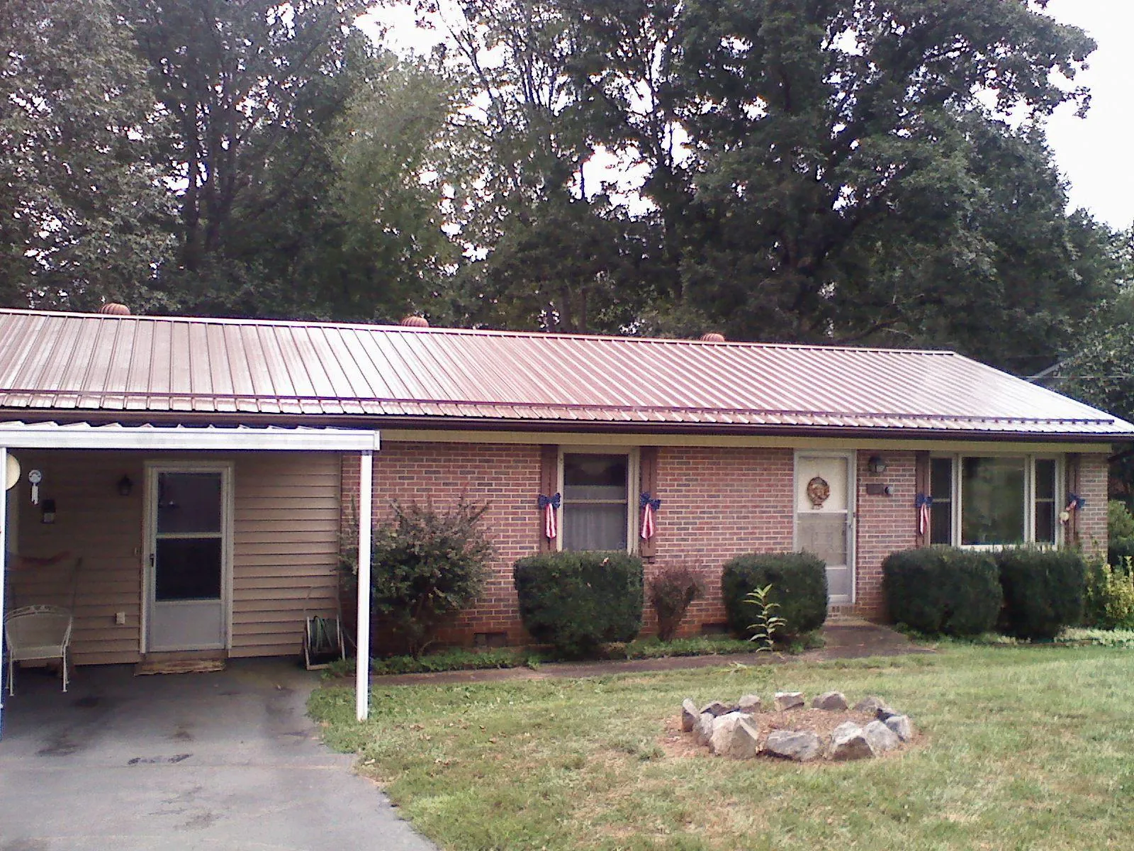 Bronze metal roof and carport on a brick ranch home — Roof Repair work by our crew in Mogadore